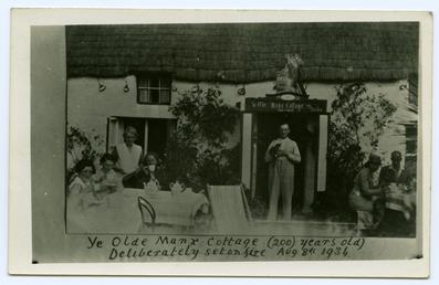Customers having tea outside 'Ye Olde Manx Cottage'