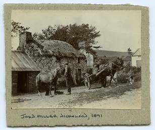 Horses and cart outside a Manx thatched cottage