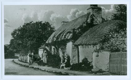 Villagers outside a thatched cottage in Colby