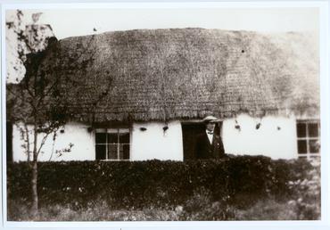Gentleman outside a thatched cottage in Patrick