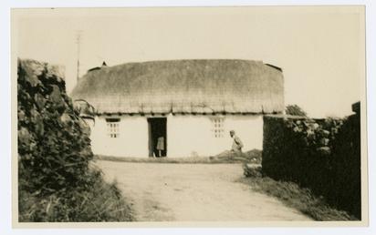 Cregneash Harry Kelly's Cottage with P.D. Wood outside.