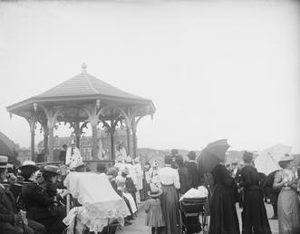 Spectators watching a pierrot show at bandstand on…