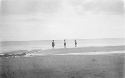 Three women paddling in the sea, fully clothed…