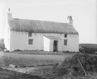 Two-storey Manx thatched cottage with porch