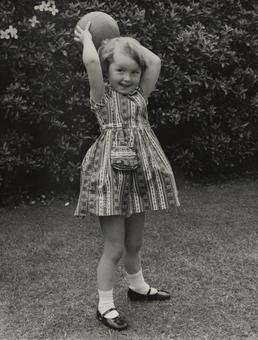 Jane Wilcox, holding a ball aloft outdoors