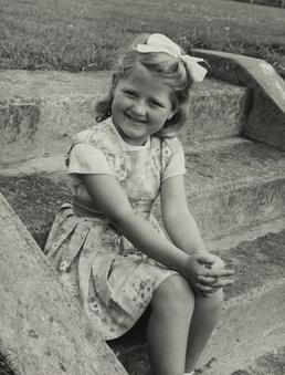 Glenis Woodman, seated on outdoor steps