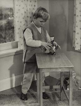 Jamie Corkill, standing at table with toy