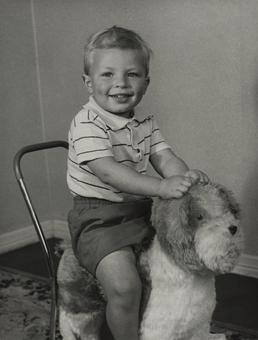 Kevin Cottier sitting on wheeled toy dog