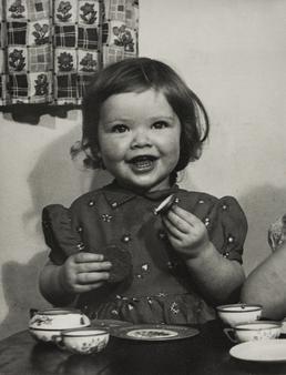 Ann Jackson seated at table with child's china…