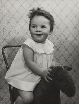 Julie Leece, sitting on child's toy horse