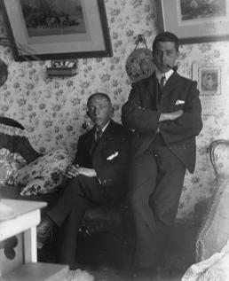 E. Simpkins and G. Halliday in a sitting-room,…