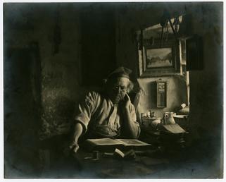 John Kinnish ('Old Pete') reading in his cottage