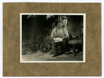 John Kinnish ('Old Pete') sitting in his cottage…