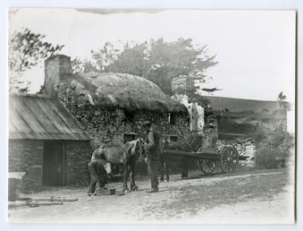 Thatched smithy with horse and cart outside