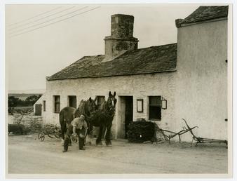 Workman and two horses outside Santon smithy